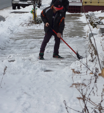 Clearing snowy sidewalk