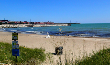 Lake Michigan beach with closed sign, cityscape in background