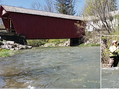 USGS hydrologist Hilary Dozier measures streamflow above a covered bridge along Fishing Creek in Pennsylvania. Photo by John Clune, USGS.